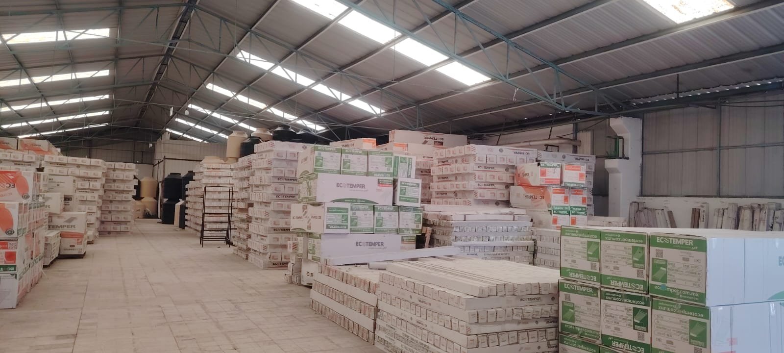 Nave industrial de SOLCAE, pasillo alto con inventario apilado.